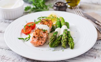Baked salmon garnished with asparagus and tomatoes with herbs